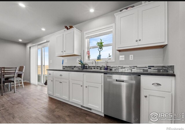 kitchen with white cabinetry, sink, stainless steel dishwasher, and a healthy amount of sunlight