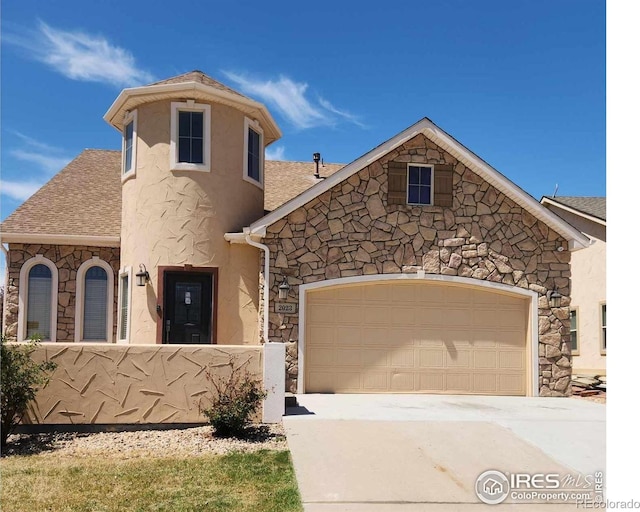 2023 81st Ave, Greeley, CO 80634 - view of front facade featuring stone siding, a shingled roof, an attached garage, and driveway