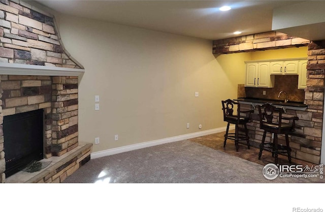 2023 81st Ave, Greeley, CO 80634 - kitchen with a fireplace, recessed lighting, tasteful backsplash, carpet floors, and white cabinetry