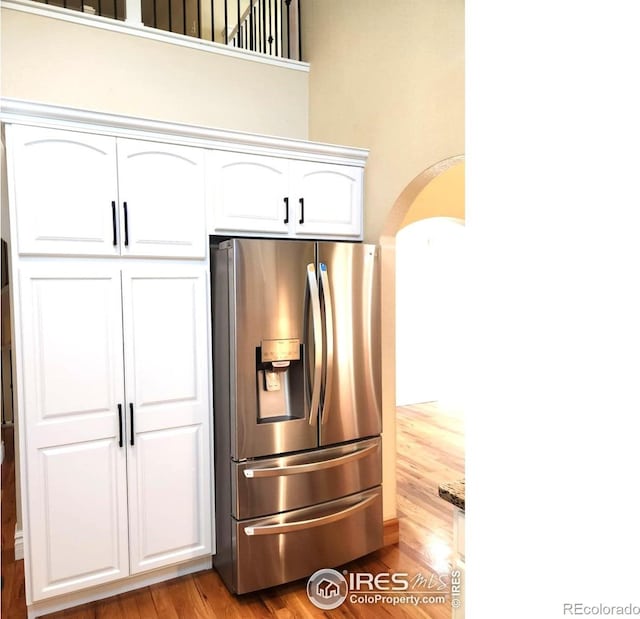 2023 81st Ave, Greeley, CO 80634 - kitchen with stainless steel refrigerator with ice dispenser, light wood-style floors, white cabinets, and arched walkways