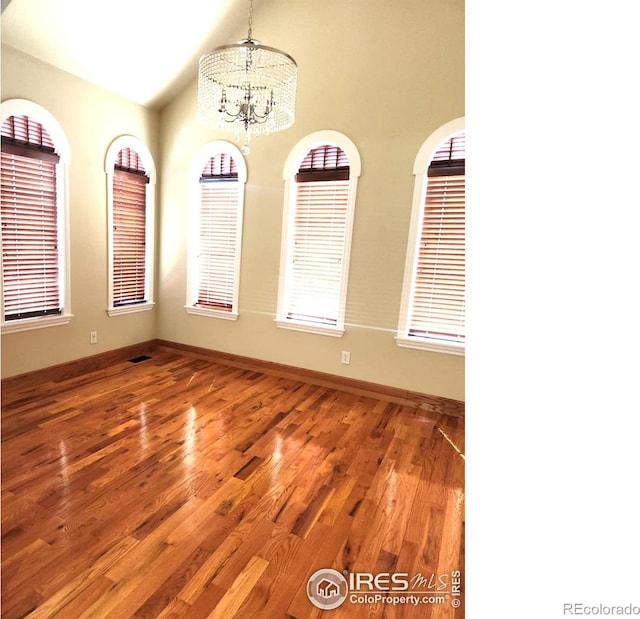 2023 81st Ave, Greeley, CO 80634 - spare room featuring a chandelier, wood finished floors, and lofted ceiling