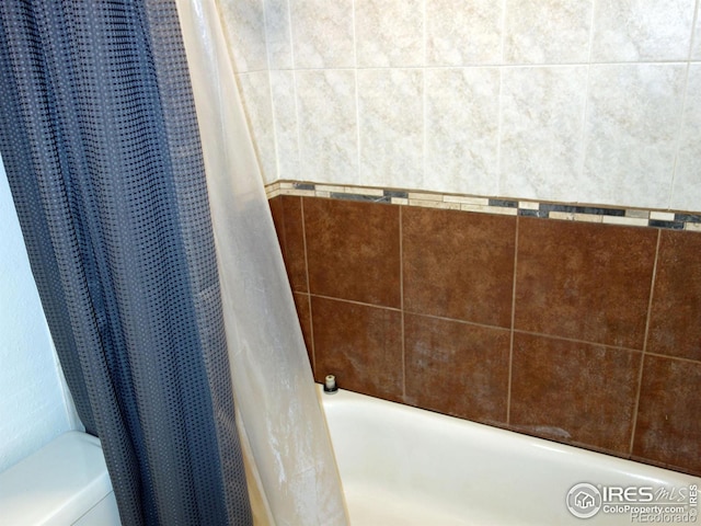 bathroom featuring shower / tub combo with curtain and toilet