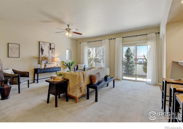 carpeted living room featuring ceiling fan