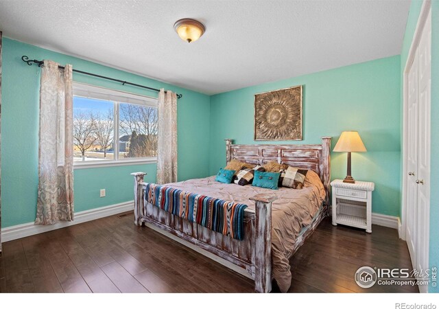 bedroom featuring dark hardwood / wood-style floors and a textured ceiling