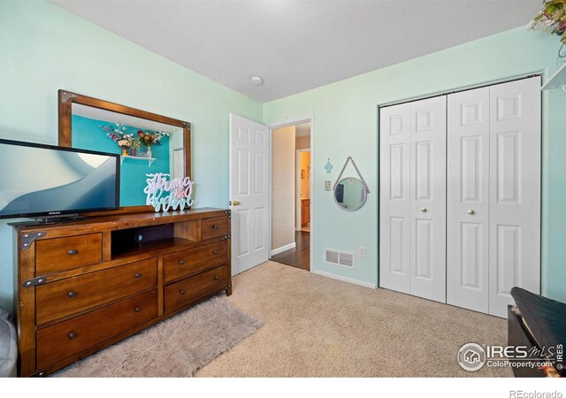 bedroom featuring light colored carpet and a closet