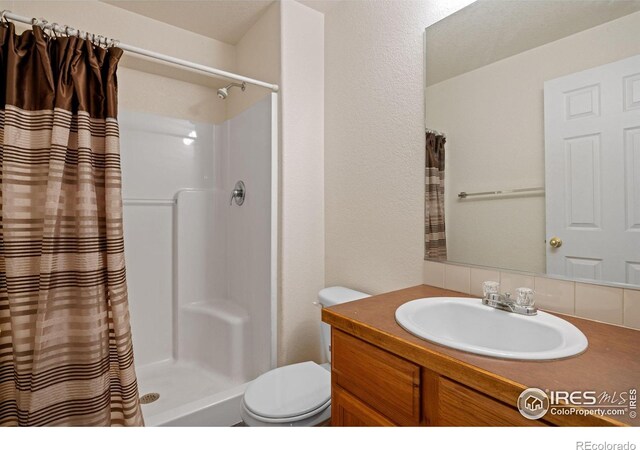 bathroom with toilet, vanity, and a shower with shower curtain