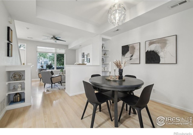 dining space featuring ceiling fan with notable chandelier and light hardwood / wood-style flooring