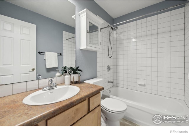 full bathroom with vanity, tiled shower / bath, and toilet