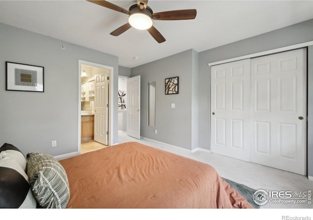 carpeted bedroom with ceiling fan, ensuite bath, and a closet