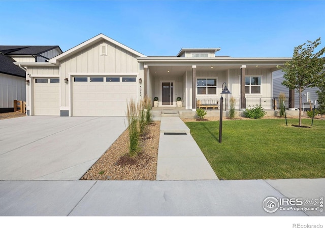 view of front of property featuring a porch, a garage, and a front yard