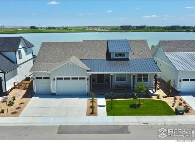 view of front of property featuring a water view, a porch, a garage, and a front lawn