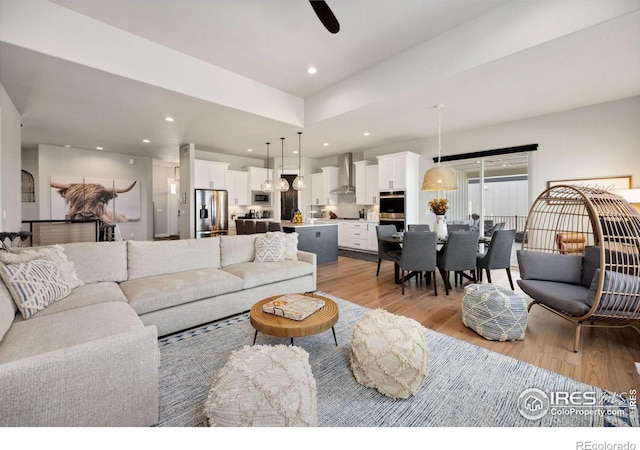 living room with ceiling fan and light hardwood / wood-style flooring