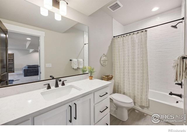 full bathroom with vanity, shower / tub combo, and toilet