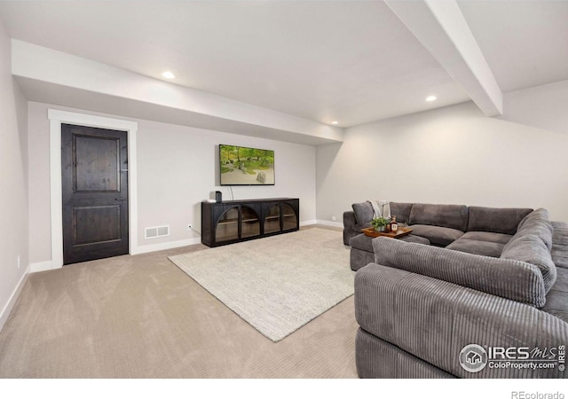 carpeted living room with beam ceiling