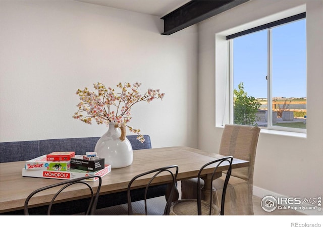 dining area featuring beamed ceiling