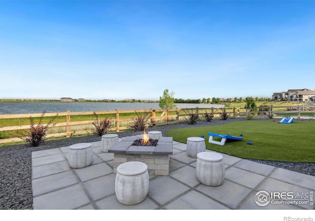 view of patio with a water view and a fire pit