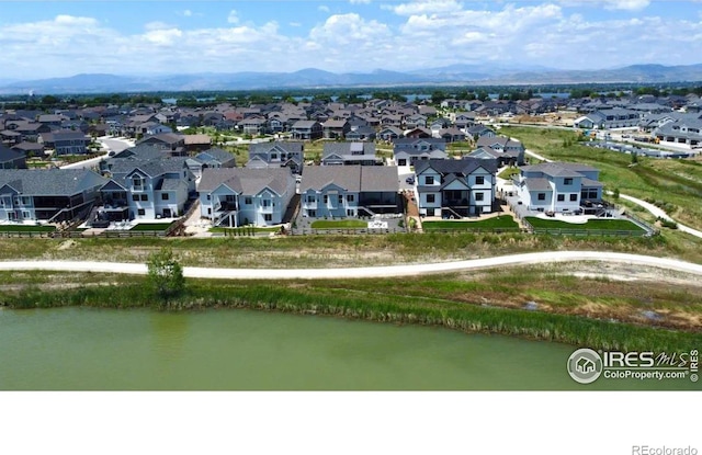 birds eye view of property with a water and mountain view