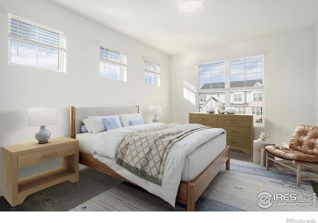 bedroom with multiple windows and light wood-type flooring