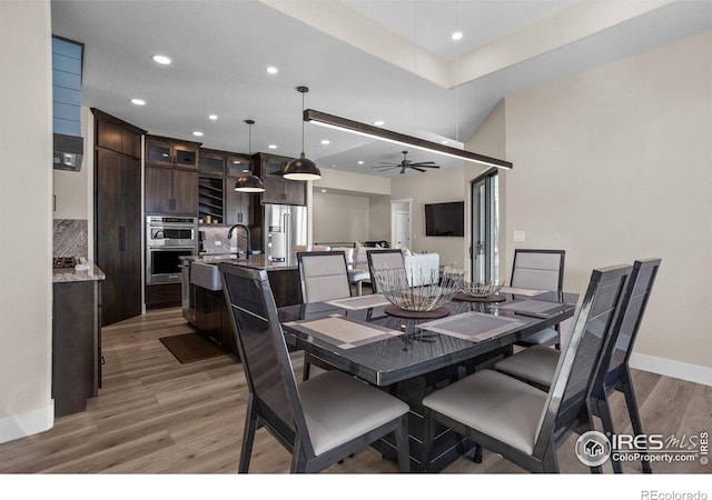 dining room featuring hardwood / wood-style flooring, ceiling fan, and sink