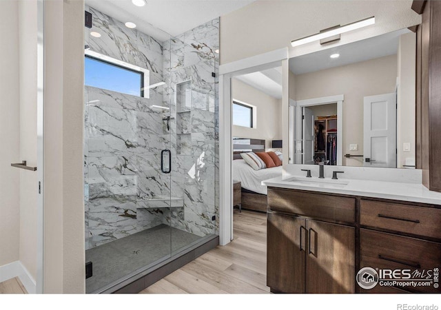 bathroom featuring vanity, hardwood / wood-style flooring, and a shower with door