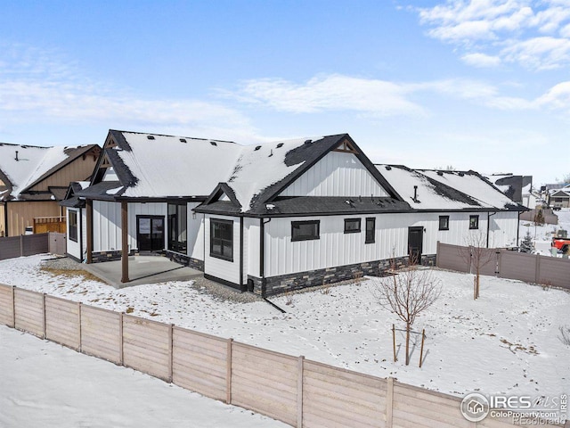 view of snow covered back of property