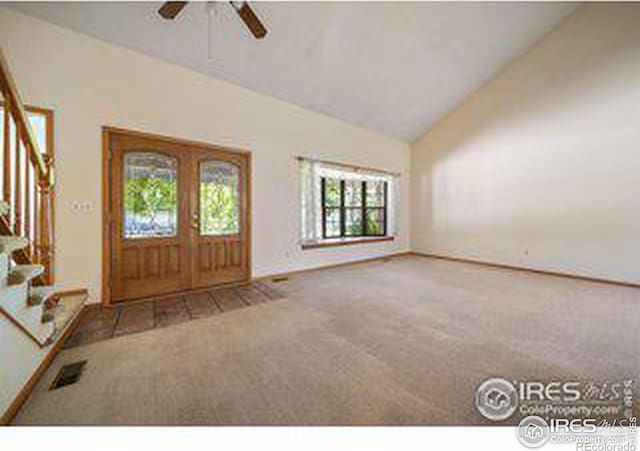 foyer with carpet floors, high vaulted ceiling, and ceiling fan