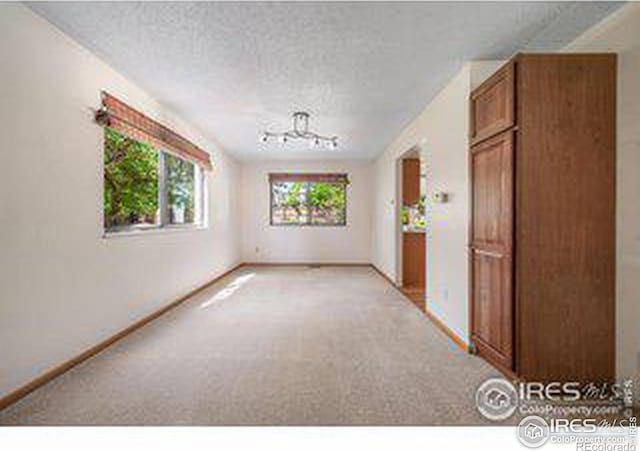 carpeted empty room with a textured ceiling