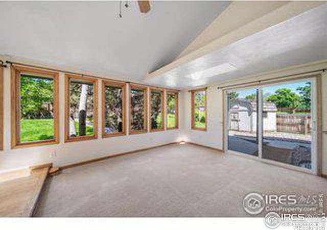 unfurnished living room featuring lofted ceiling, carpet floors, and ceiling fan