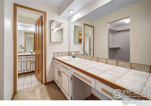 bathroom with vanity and beam ceiling