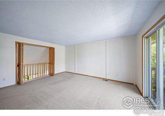 unfurnished room featuring carpet and a textured ceiling