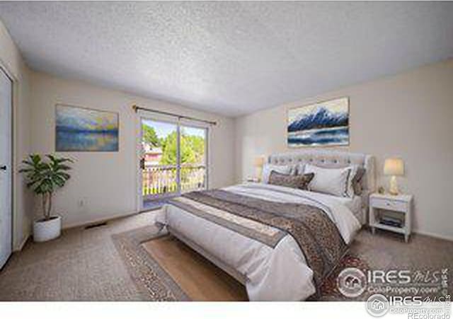 carpeted bedroom featuring a textured ceiling and access to outside