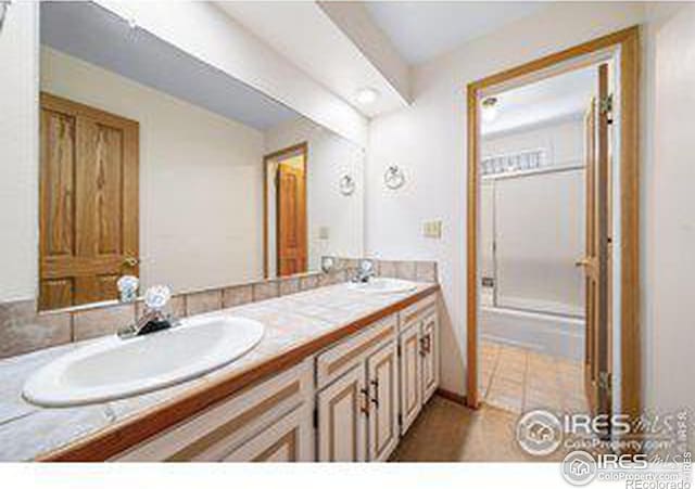 bathroom with vanity and a shower with shower door