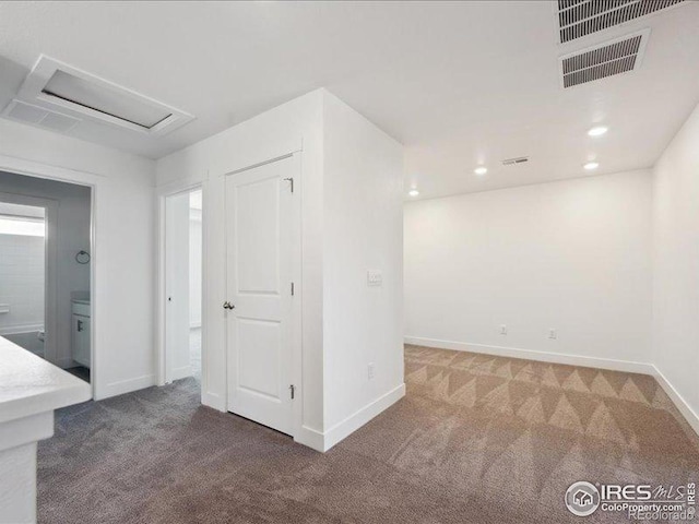 unfurnished room with carpet flooring, attic access, baseboards, and recessed lighting