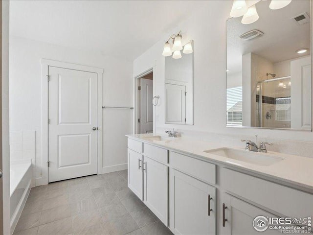 full bathroom featuring a shower stall, double vanity, tile patterned floors, and a bath