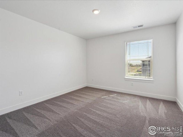 unfurnished room with carpet and baseboards