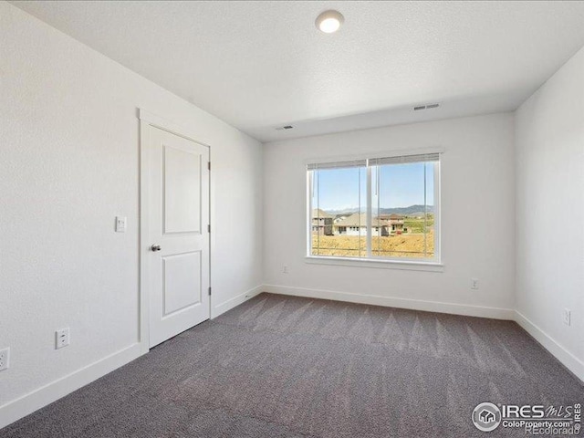 carpeted empty room with baseboards