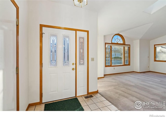 foyer with light colored carpet and lofted ceiling