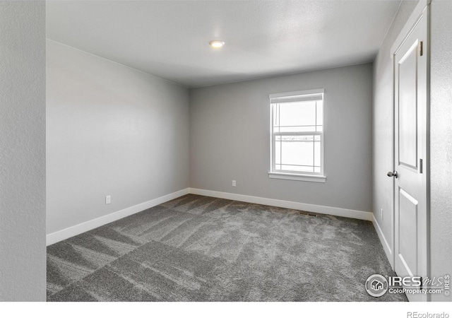 empty room featuring dark carpet