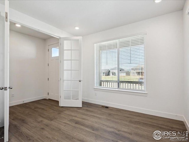 spare room featuring baseboards, wood finished floors, recessed lighting, and french doors
