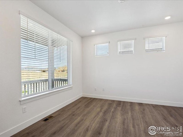 unfurnished room featuring dark wood-type flooring, baseboards, and recessed lighting