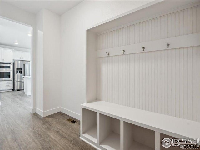 mudroom featuring wood finished floors and baseboards