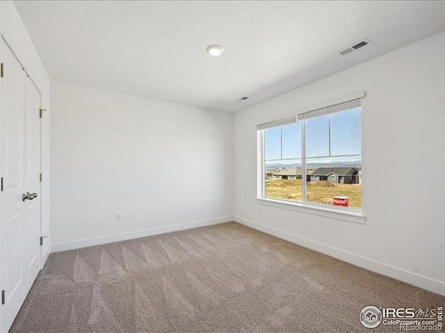 unfurnished room with carpet flooring and baseboards