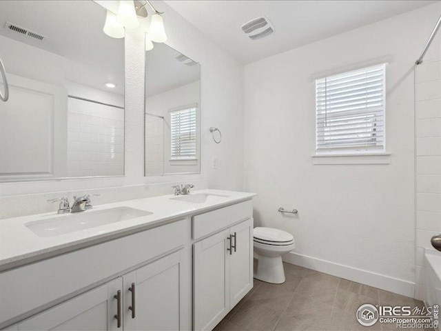 bathroom featuring toilet, double vanity, baseboards, tile patterned flooring, and  shower combination