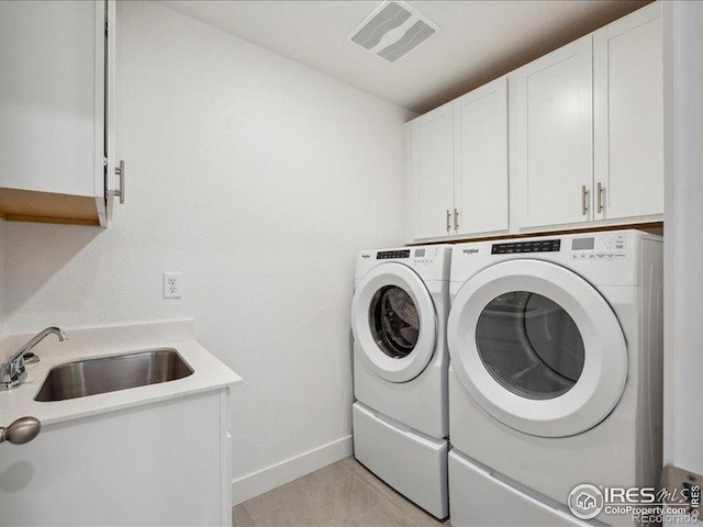 laundry area with cabinet space, washing machine and clothes dryer, and baseboards