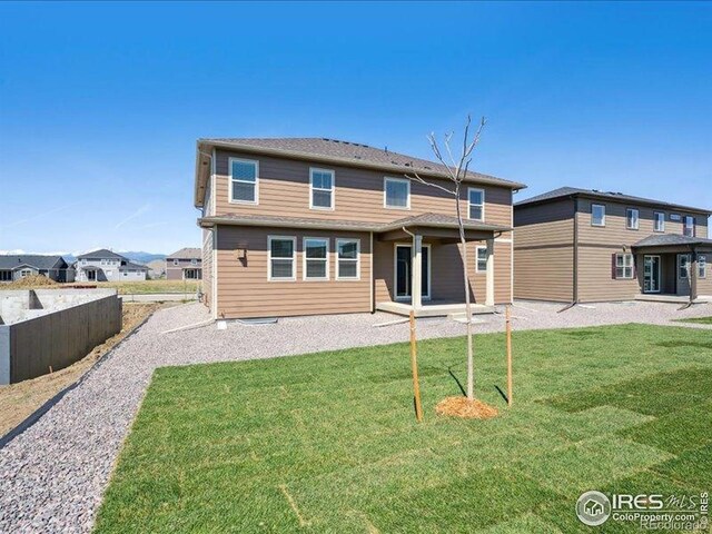 rear view of house with a lawn and a patio
