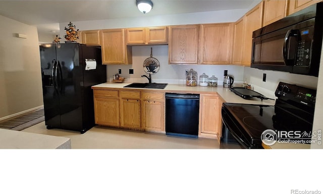 kitchen with sink, light brown cabinetry, and black appliances