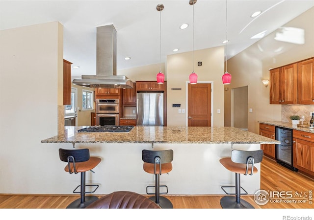 kitchen with wine cooler, island range hood, a kitchen breakfast bar, pendant lighting, and stainless steel appliances