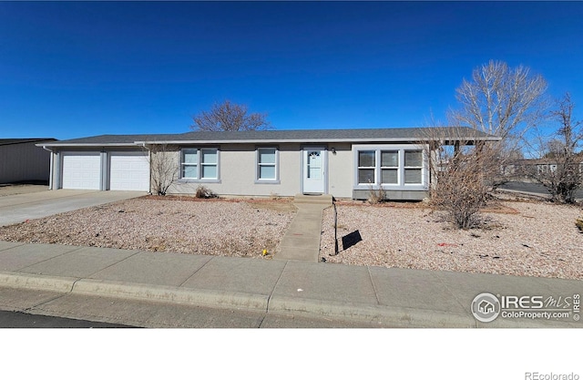 single story home featuring concrete driveway and an attached garage