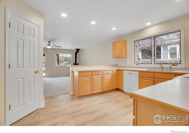 kitchen featuring white dishwasher, sink, kitchen peninsula, and light brown cabinetry