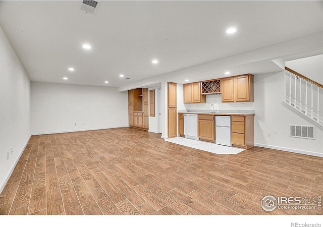kitchen with refrigerator, dishwasher, sink, and light wood-type flooring